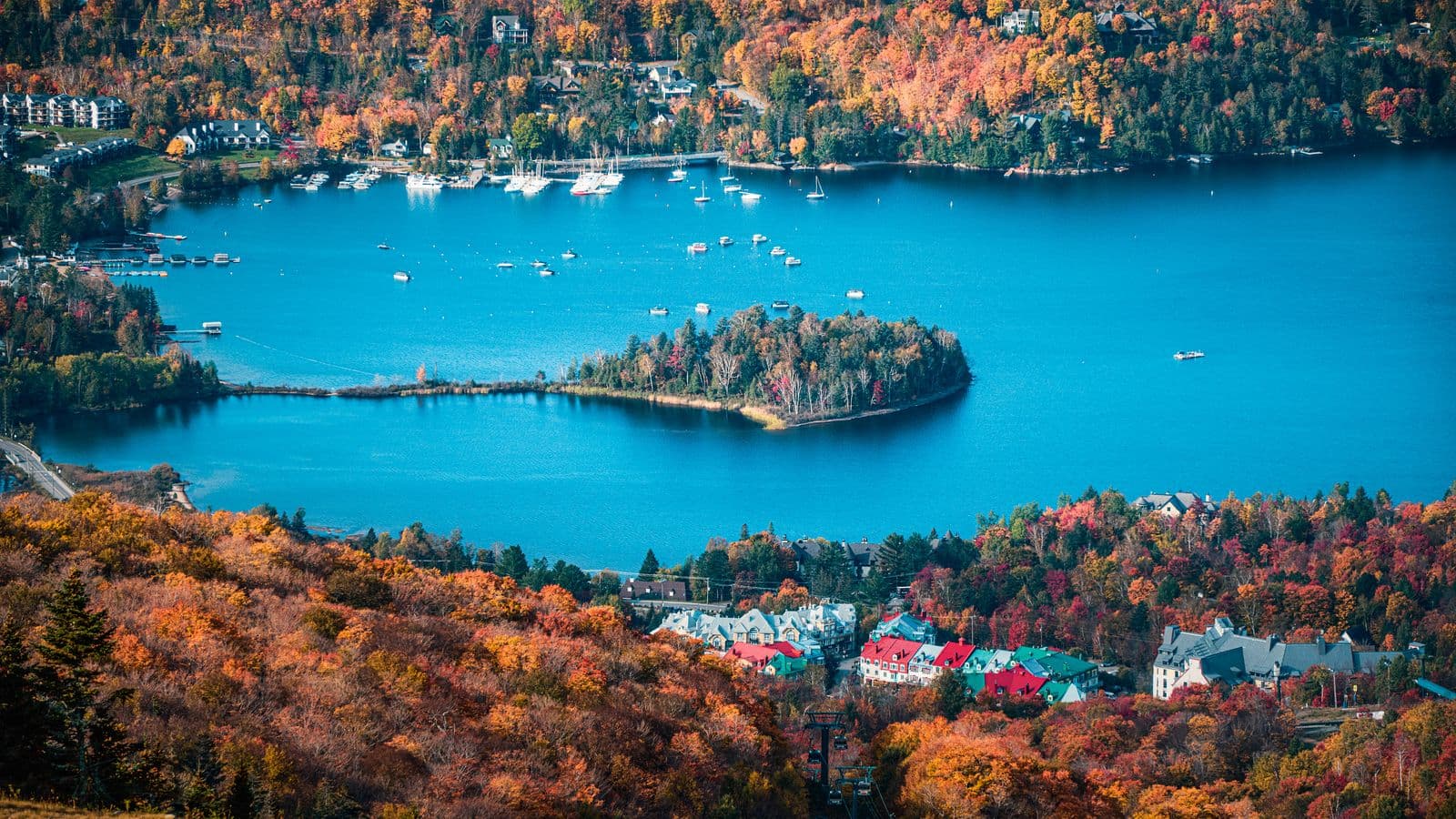 Le village de Mont-Tremblant et son lac, entourés de forêts aux couleurs d’automne.