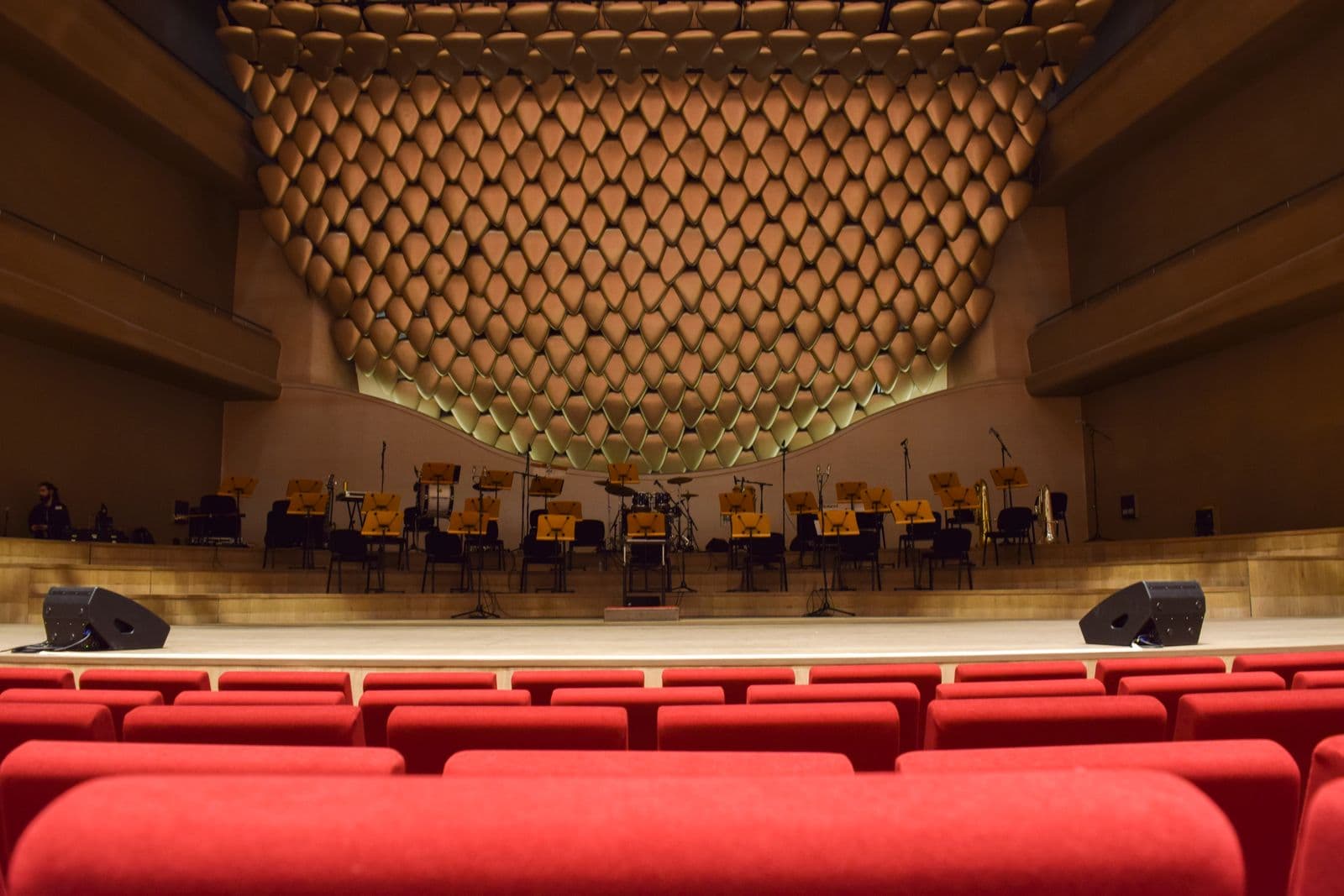 Une salle de concert prête avant le spectacle, pupitres et instruments en place.