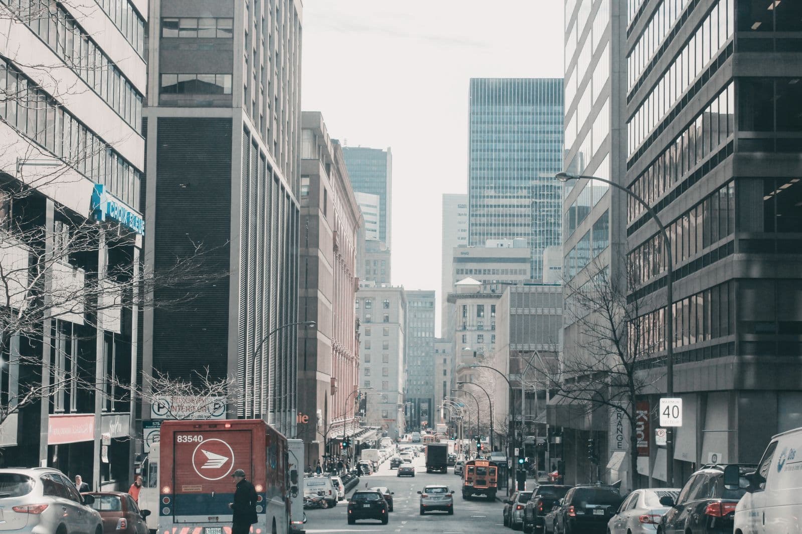 Une rue du centre-ville de Montréal, entre les tours et la circulation.